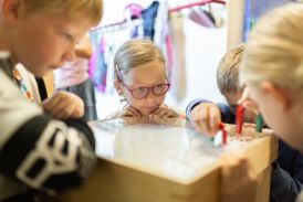 Schülerinnen und Schüler spielen mit einem Magnetspiel